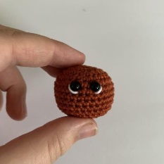 Ukázka, jak má vypadat hotová hlava podle návodu na háčkovaný přívěsek kočičku.